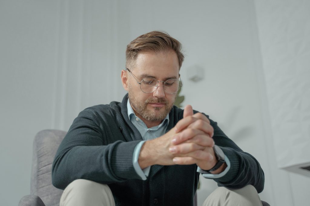 homem transmitindo frustração ou incómodo, sobre fundo neutro.