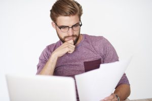 Homem pensativo a estudar as diferenças entre a Técnica Egydio e a plicatura de Nesbit após consultar um especialista