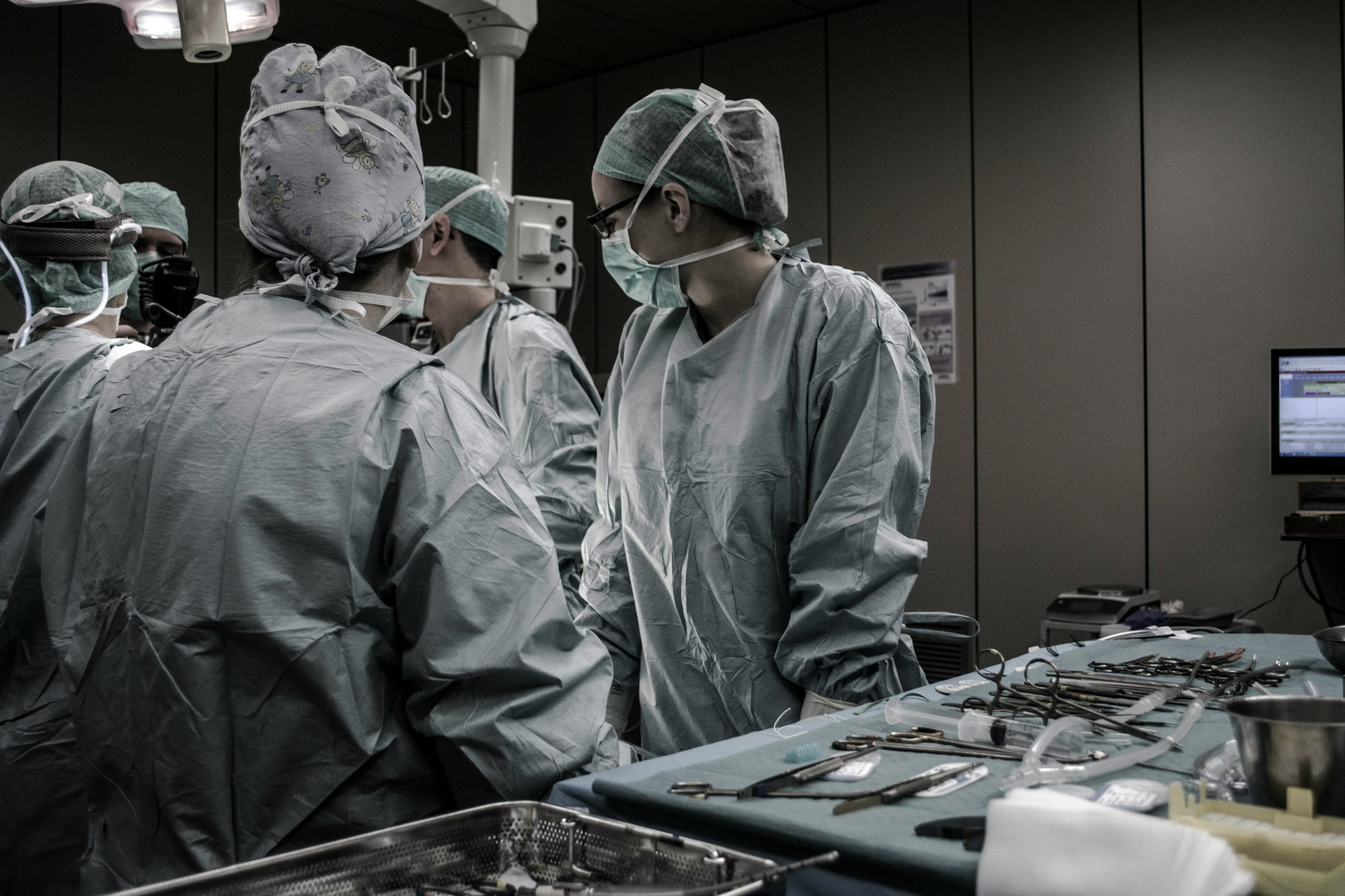Equipa médica em bloco operatório durante uma intervenção cirúrgica, com instrumentos preparados para cirurgia de reconstrução peniana