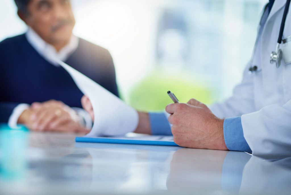 Urologista analisa exames e historial clínico na primeira consulta de Doença de Peyronie