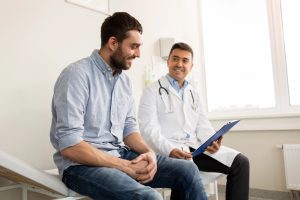 Médico autoriza o doente a retomar as relações sexuais após a cirurgia de Peyronie, em ambiente clínico.