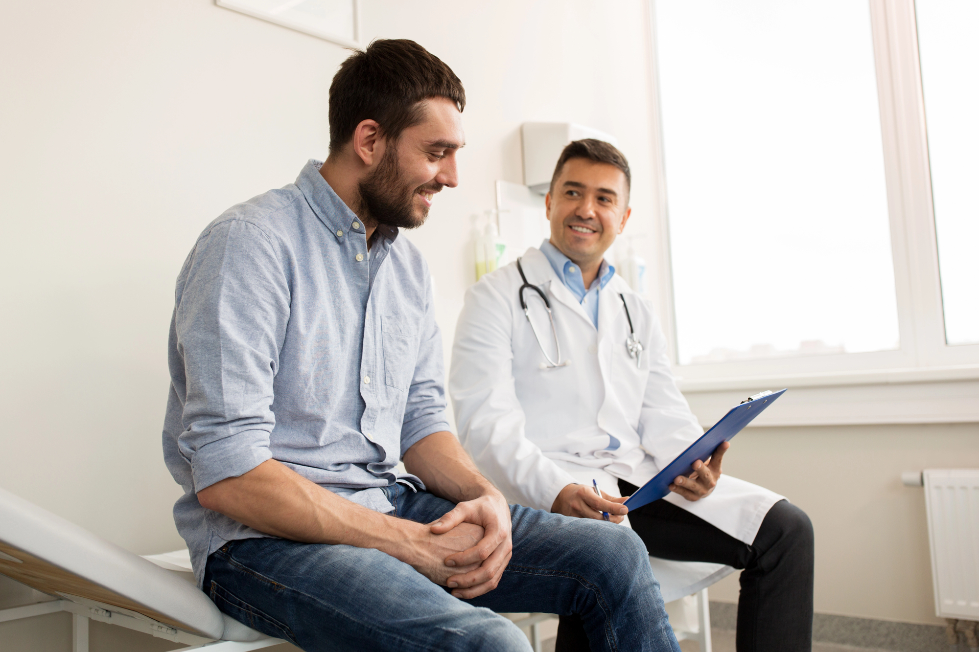 Médico autoriza o doente a retomar as relações sexuais após a cirurgia de Peyronie, em ambiente clínico.