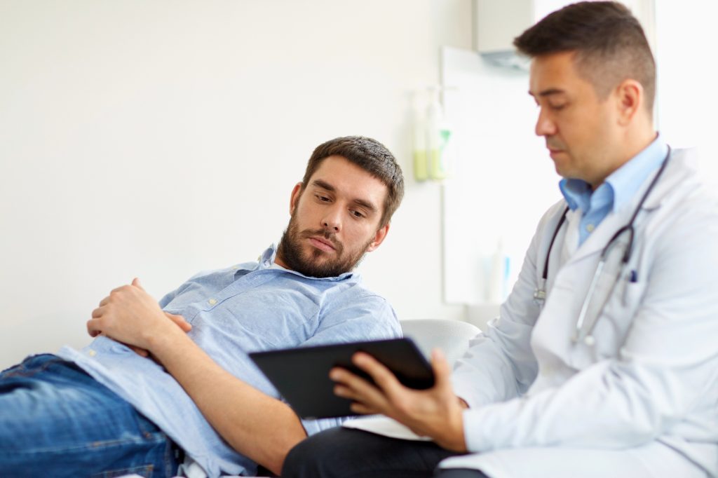 Doente no urologista em ambiente clínico entendendo a relação entre tabagismo e doença de peyronie