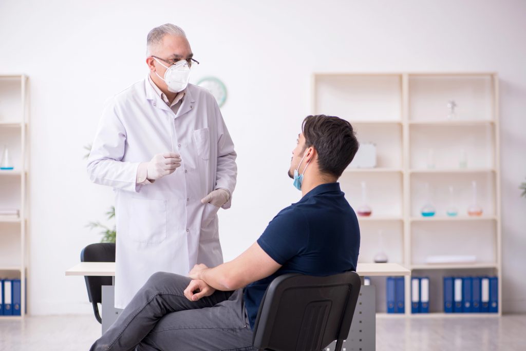 Doente em ambiente de consultório falando com urologista sobre como é viver com prótese peniana